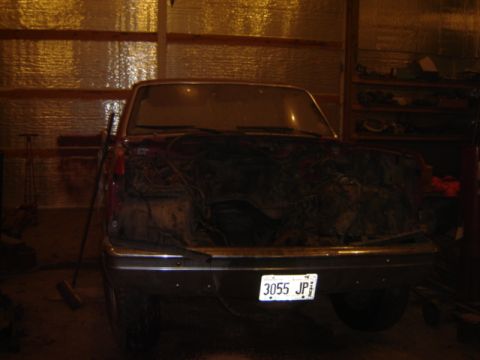 1992 Ford Bronco - This dark red pickup truck is missing its engine, with its hood open and the front grille visible. The license plate reads 3055 JP.
