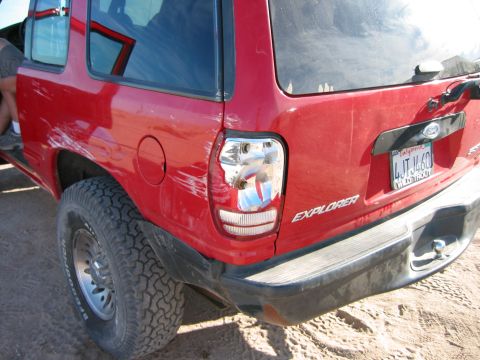 1997 Ford Ranger - Rear view of a red SUV with visible body damage and a California license plate.