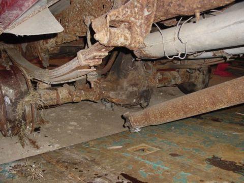 1992 Ford Bronco - Close-up view of heavily corroded rear axle and suspension components on a vehicle.