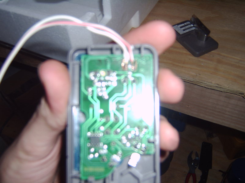 Circuit board with green PCB and wires held by a hand