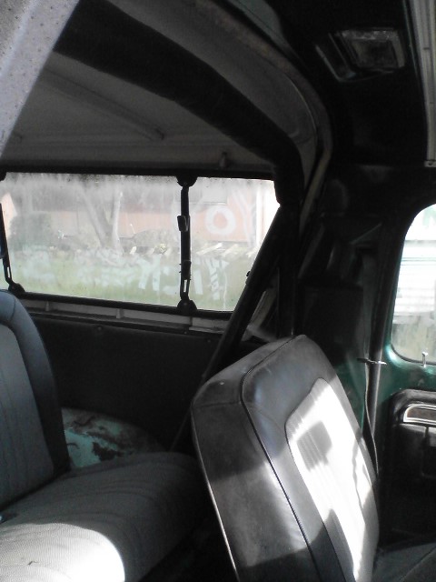 1978 Ford Bronco - The interior of a green SUV is visible, including seats and a roll cage.