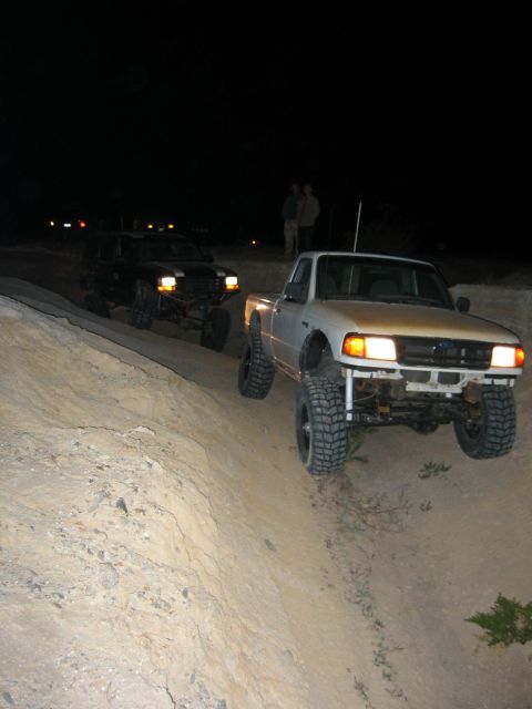 1997 Ford Ranger - A white 1997 Ford Ranger navigates a dirt path at night, with another off-road vehicle following behind.