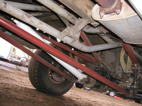 1984 Ford Bronco - Undercarriage view showing suspension components, exhaust, and a tire. No visible year-identifying features.