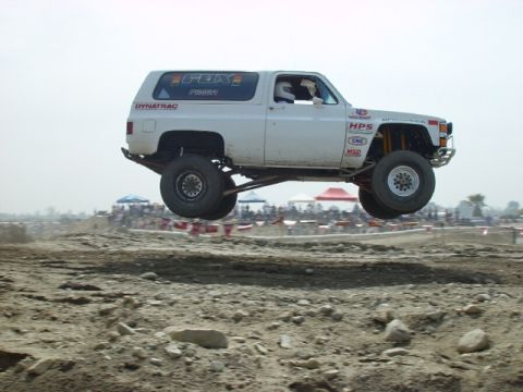 1984 Ford Bronco - Off-road truck airborne during a race event. Appears to be a 1973 model, not a 1984 Ford Bronco.