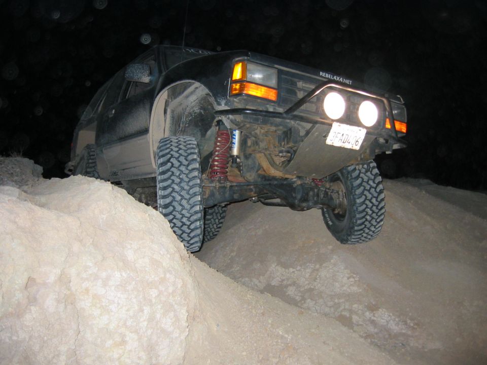 1997 Ford Ranger, black, off-road tires, lifted suspension, driving on dirt mound at night