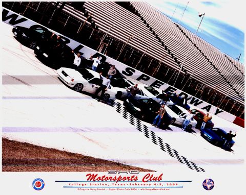 1996 Ford Probe - Cars and people gathered at a speedway, with grandstands visible in the background.