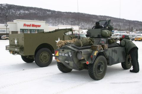 2003 Jeep TJ - Two military vehicles are parked in a snowy lot in front of a Fred Meyer store.