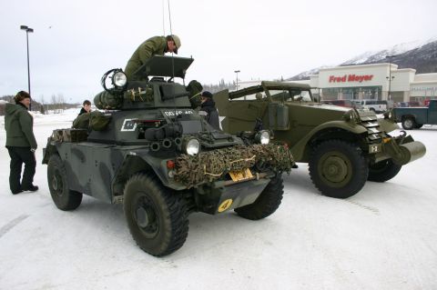 2003 Jeep TJ - Two military vehicles are parked in a snowy lot outside a Fred Meyer store.
