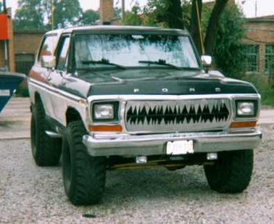 1979 Ford Bronco - A modified 1978 Ford Bronco with a distinctive grille sits parked on a gravel lot.