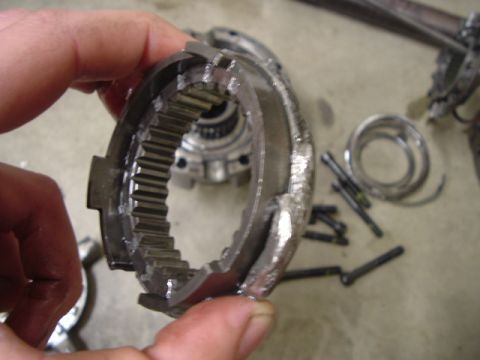 1989 Ford Bronco - A damaged gear part is held up for inspection, with other mechanical components visible on the surface below.