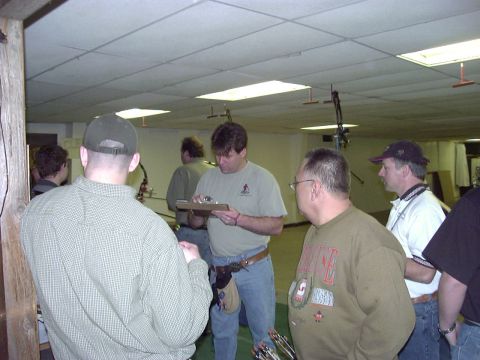 1992 Ford Bronco - People gather at an indoor archery range, with targets and equipment visible in the background.