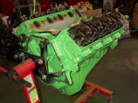 1978 Ford Bronco - A green V8 engine is mounted on an engine stand, ready for work in a garage setting.