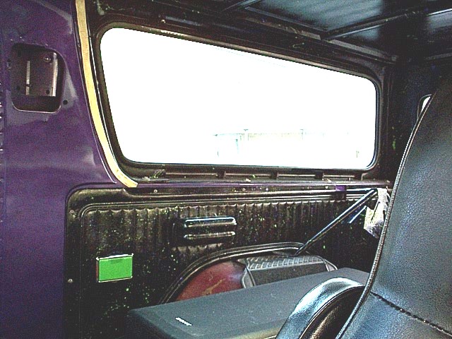 Purple interior panel and seat inside a vehicle, looking out the side window