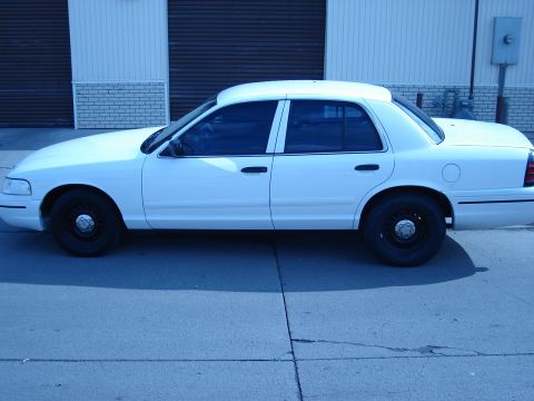 2000 Ford Crown Victoria - Side view of a white 2000 Ford Crown Victoria sedan with tinted windows and black steel wheels.