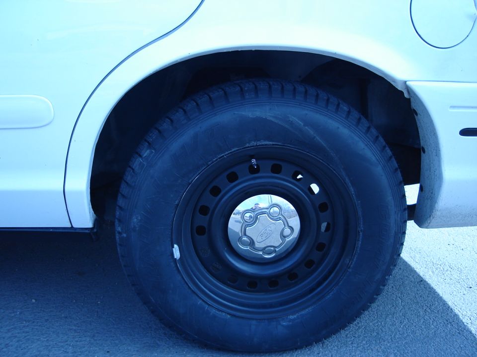2000 Ford Crown Victoria rear wheel and tire with steel rim and hubcap
