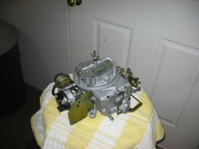 Holley carburetor on a yellow and white striped towel in front of a white door