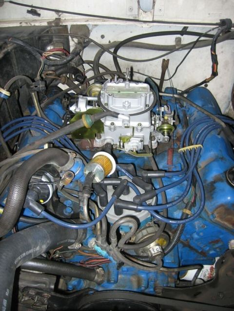 1979 Ford Bronco - Close-up view of a vehicle's engine compartment, focusing on the carburetor and associated wiring.