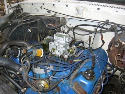 1979 Ford Bronco - The engine bay of a 1979 Ford Bronco, showing the carburetor and associated components.