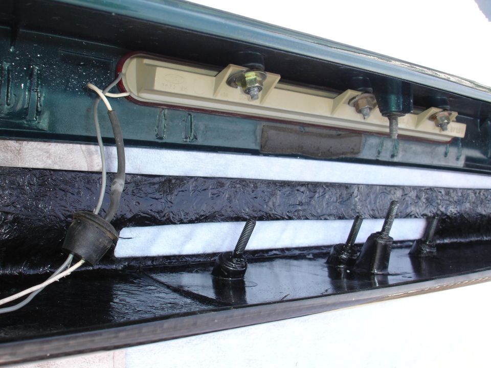 Inside of a car trunk, showing wiring and mounting hardware for a light