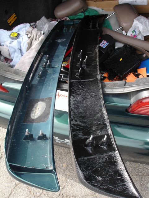 1995 Ford Taurus - Two car spoilers are shown, one green and one black, with mounting hardware visible.