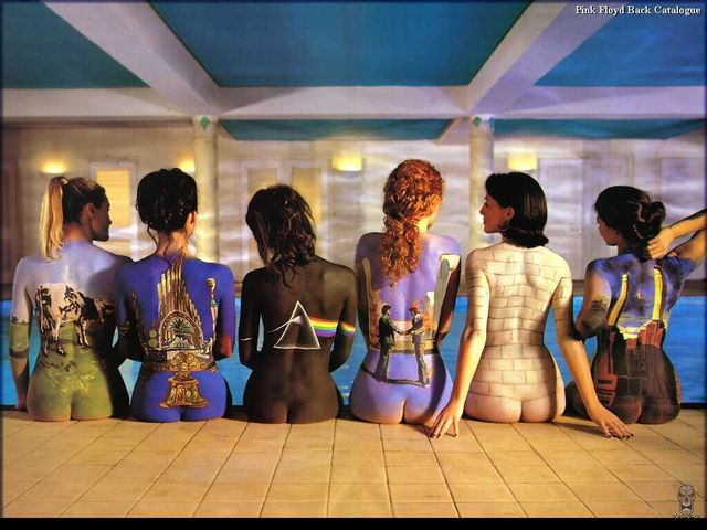 Six people sit facing away, their backs painted with album art and imagery