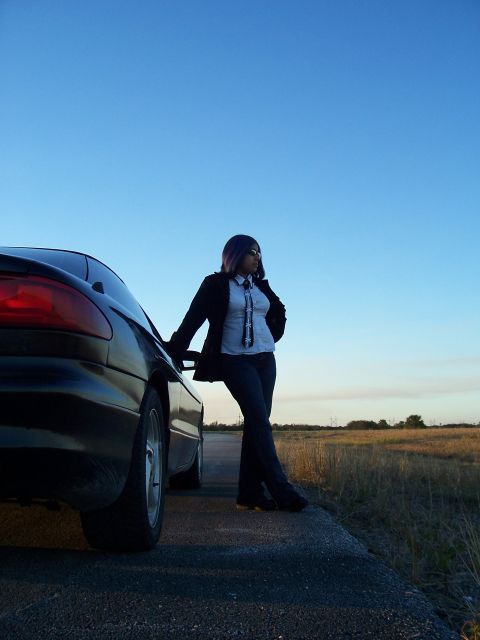 1994 Ford Probe - A woman poses with a car against a clear blue sky at dusk.