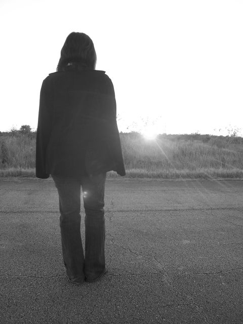 1994 Ford Probe - A person stands on an asphalt road, silhouetted against a bright sunset.