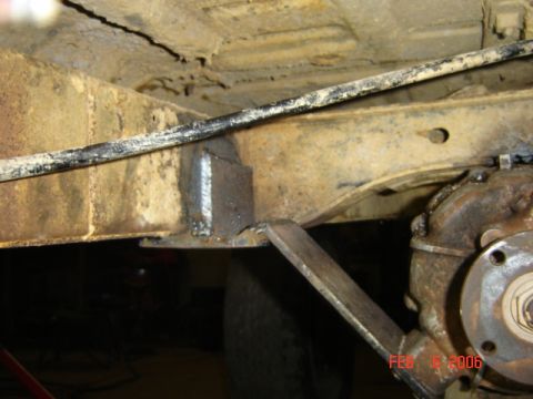 1982 Nissan Titan - Close-up view of a vehicle's undercarriage, highlighting the transmission and frame with a visible weld modification.