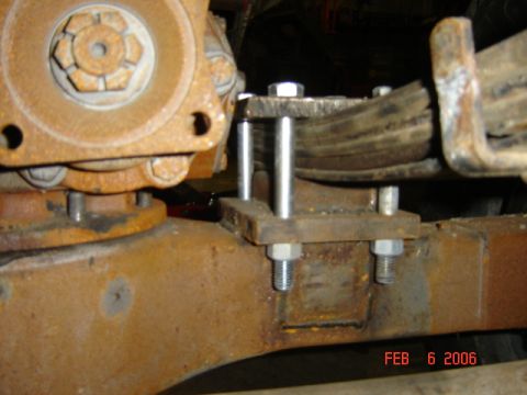 1982 Nissan Titan - Close-up of a rusty leaf spring and differential housing assembly.