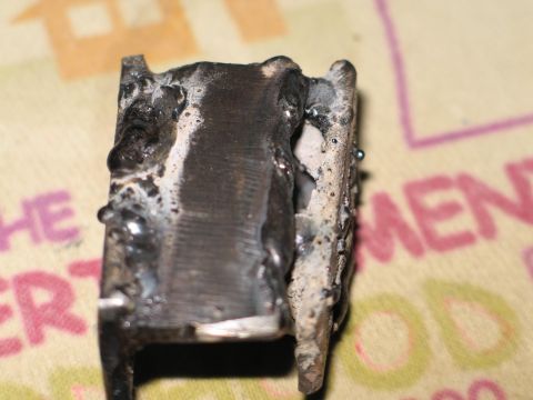 1995 Ford Bronco - A close-up view of a metal part with extensive welding, showing a rough and unfinished texture.