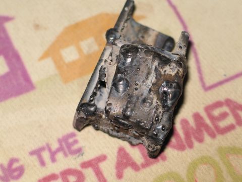 1995 Ford Bronco - A close-up view of a metal component that has been welded, showing numerous imperfections in the weld beads.