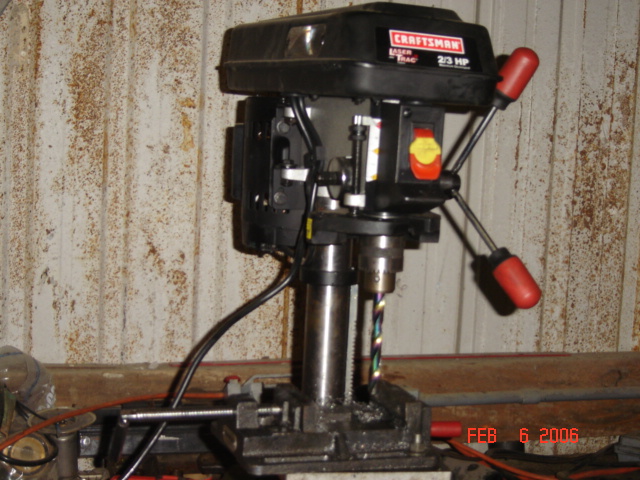 Craftsman drill press with red handles and a drill bit