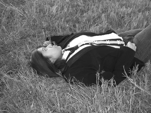 1994 Ford Probe - A woman rests in a grassy field, her gaze directed upwards.
