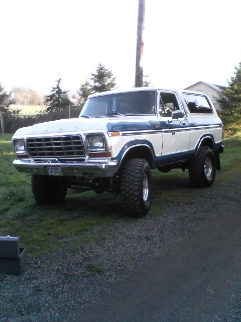 1978 Ford Bronco - This two-tone 1978 Ford Bronco is shown from a 3/4 front angle, highlighting its lifted suspension and large off-road tires.