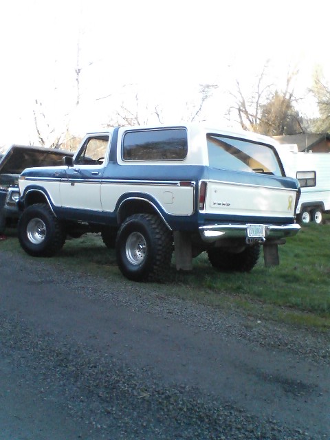 1978 Ford Bronco - Rear view of a lifted 1978 Ford Bronco with blue and white paint, parked outdoors.
