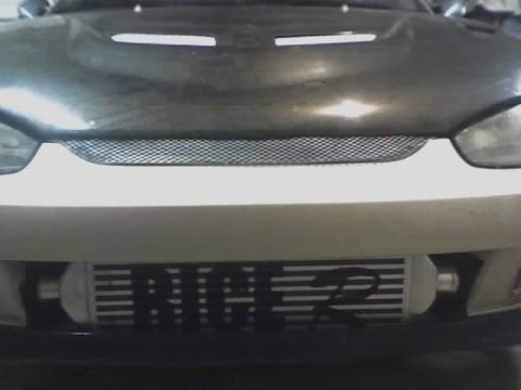 1999 Mitsubishi Mirage - Front view of a car a carbon fiber hood and an intercooler with "RICE 2" visible.
