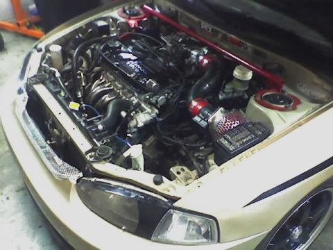 1999 Mitsubishi Mirage - Engine bay of a 1999 Mitsubishi Mirage, modified with an aftermarket intake and strut bar.