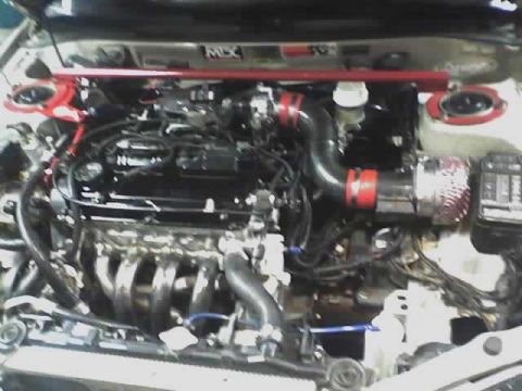 1999 Mitsubishi Mirage - The engine bay features a modified intake system and a red strut tower brace.