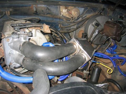 1986 Ford Bronco - Engine bay with custom intercooler and intake plumbing, likely modified.