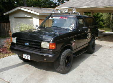 1989 Ford Bronco - This black Ford Bronco, likely a 1987 model, is shown from a three-quarter front angle with its distinctive body style.