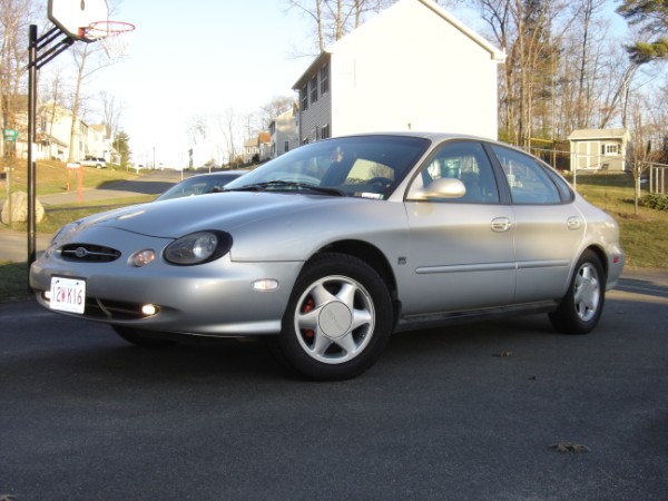 Silver sedan parked on asphalt, front quarter view. Visible license plate reads 2WK16