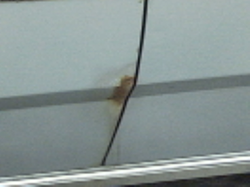 Gray car door with rust spot and black trim