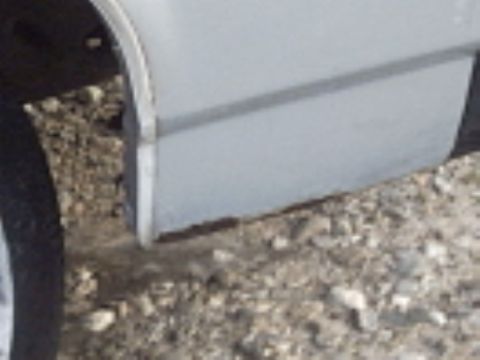 1991 Ford LTD Crown Victoria - Close-up view of a vehicle's side panel, showing some rust along the lower edge.
