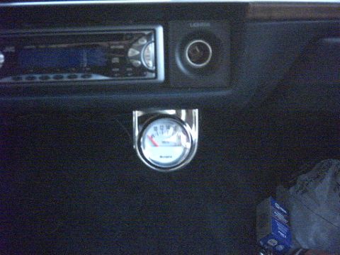 1991 Ford LTD Crown Victoria - A dimly lit dash shot showing an aftermarket single-DIN CD head unit with blue display fitted in the center stack below woodgrain trim, plu…