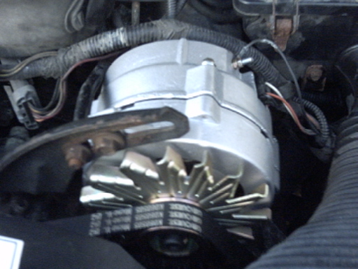 Close-up of a vehicle alternator with drive belts