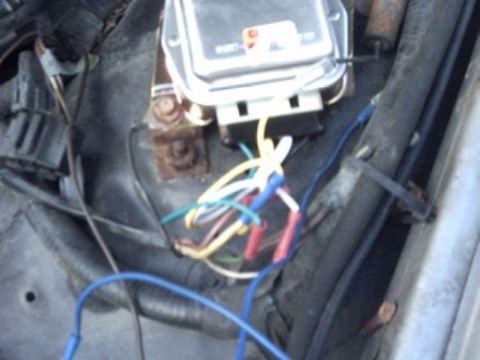 1991 Ford LTD Crown Victoria - Close-up view of an engine wiring harness with various colored wires and connectors attached to a component.