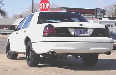 2000 Ford Crown Victoria - Rear view of a white 2000 Ford Crown Victoria, aftermarket wheels and tinted taillights.