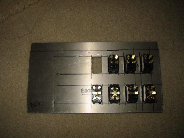 Metal panel with seven toggle switches and one blank cutout, marked with lines and 'PASS' and 'BACK'