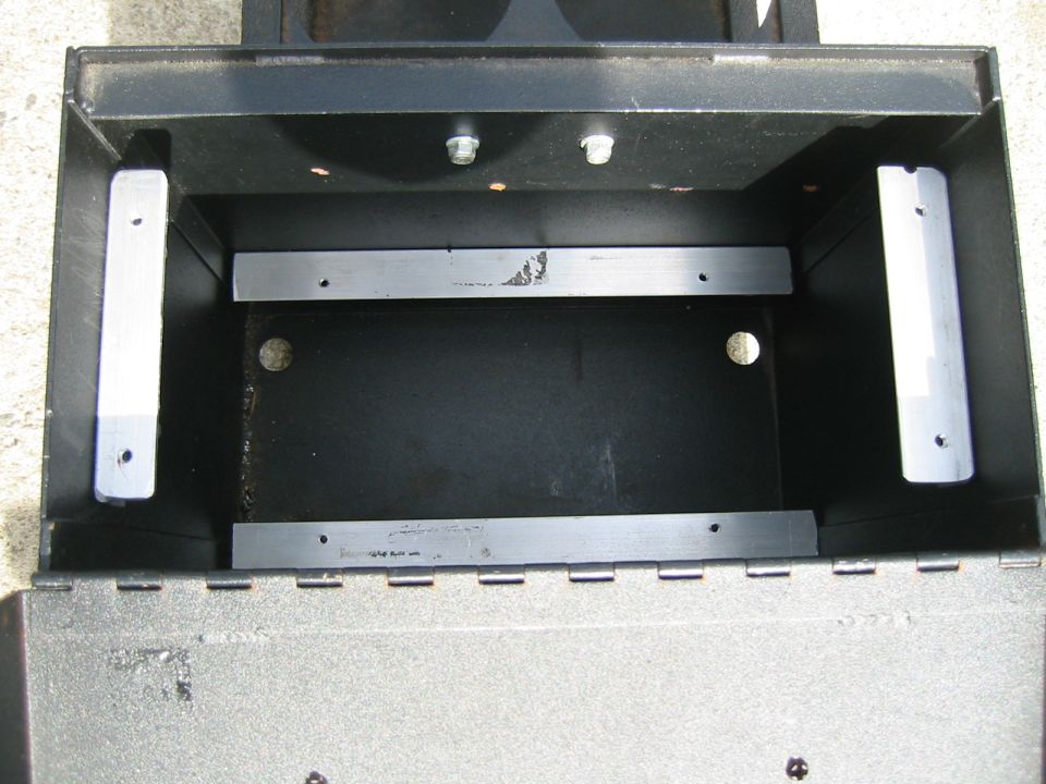 Empty black metal storage box with silver mounting brackets inside