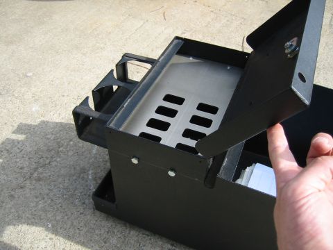 1992 Ford Bronco - This black metal organizer has cup holders and a hinged lid, placed on a concrete surface.